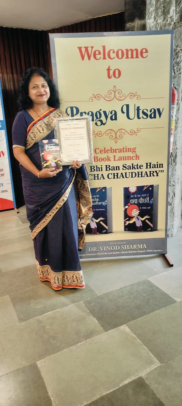 Holding a certificate beside the Pragya Utsav book launch banner
